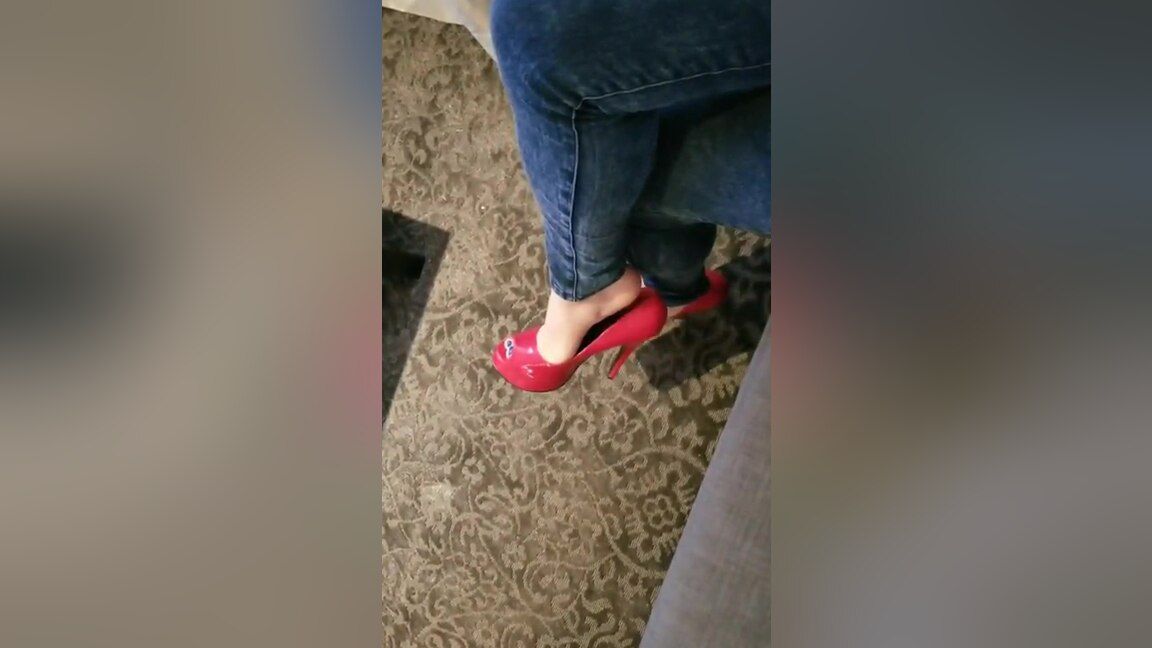 Dominant Bored Elegant Woman In Tight Blue Jeans Dangling Her Red High Heel Shoes Pain - 1