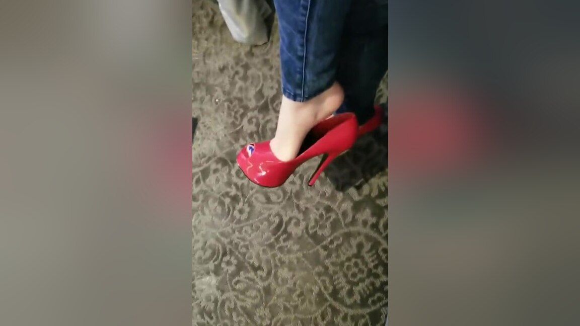 Threeway Bored Elegant Woman In Tight Blue Jeans Dangling Her Red High Heel Shoes Free